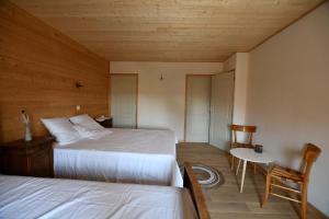 a bedroom with two beds and a table and a chair at L'oiseau Blanc 