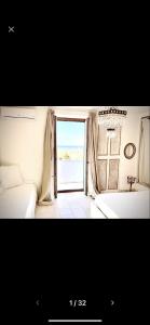 a bedroom with a large window with a view of the ocean at MAREULIVI in Ostuni