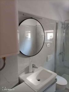 a white bathroom with a sink and a mirror at Apartment Medulin 30 in Medulin