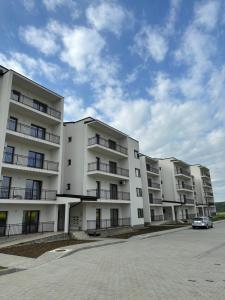 a white apartment building with a car parked in front at Dacia Apartments in Sebeş