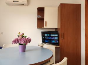 a room with a table with a vase of flowers on it at Apartment Rose in Krk