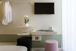 ein Wohnzimmer mit einem TV und einem rosa Stuhl in der Unterkunft Pan di Zenzero in Rimini
