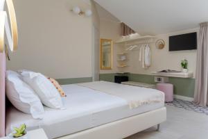 een slaapkamer met een wit bed en een televisie bij Pan di Zenzero in Rimini