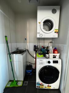 a laundry room with a washing machine and a sink at Entire One Bedroom Apartment, Penrith in Kingswood