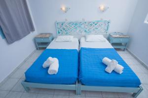 een slaapkamer met een blauw bed en handdoeken bij Pico Bello Patmos 22 in Patmos