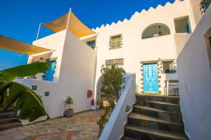 ein weißes Gebäude mit einer Treppe davor in der Unterkunft Pico Bello Patmos 22 in Patmos