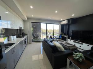 a kitchen and living room with a couch and a table at Entire One Bedroom Apartment, Penrith in Kingswood