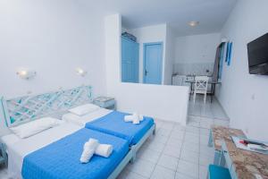 a bedroom with a blue and white bed and a table at Pico Bello Patmos 22 in Patmos