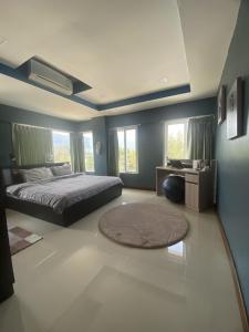 una camera con letto, scrivania e finestre di Khanom Beach Residence 1-bedroom Mountain & Sea View a Khanom