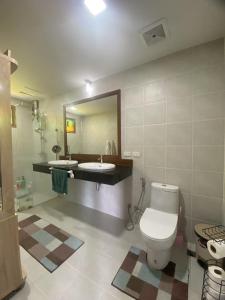 bagno con servizi igienici, lavandino e specchio di Khanom Beach Residence 1-bedroom Mountain & Sea View a Khanom