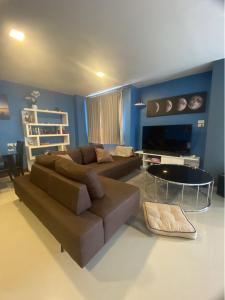un soggiorno con divano marrone e tavolo di Khanom Beach Residence 1-bedroom Mountain & Sea View a Khanom