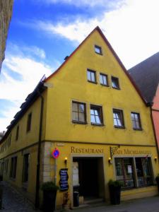 a yellow building with a sign on the side of it at Gästezimmer Michelangelo in Rothenburg ob der Tauber