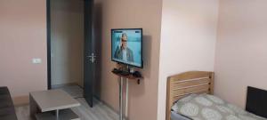 Zimmer mit einem TV an der Wand und einem Bett in der Unterkunft Full house in Tbilisi City