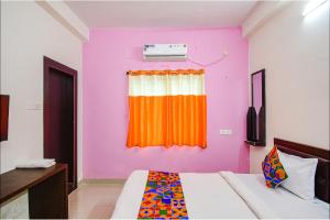 a bedroom with an orange and purple wall at FabExpress SR in Bārang