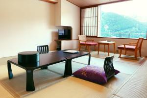 a living room with a table and chairs at Naruko Kanko Hotel in Osaki