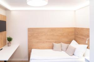 un letto con cuscini bianchi in una stanza di MM-Apartments Hainfeld a Hainfeld