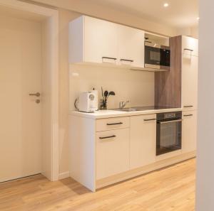 a kitchen with white cabinets and a sink at MM-Apartments Hainfeld in Hainfeld