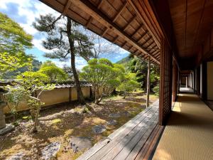 un porche de una casa con vistas a un bosque en Guest House Shimoze Agematsu, en Iida