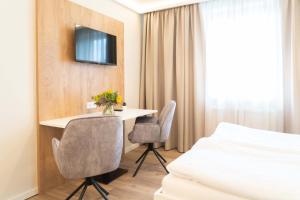 a hotel room with a bed and a desk and chairs at MM-Apartments Hainfeld in Hainfeld