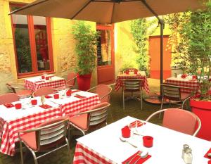 ein Restaurant mit Tischen, Stühlen und einem Sonnenschirm in der Unterkunft L'Estaminet in Mazille