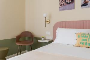 a bedroom with a bed and a chair in it at Pan di Zenzero in Rimini
