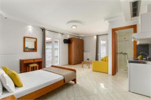 een slaapkamer met een groot bed en een keuken bij Agyra Seaview Hotel by Panel Hospitality in Nei Poroi