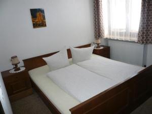 1 dormitorio con 1 cama con sábanas y almohadas blancas en Haus Windegga, en Brand