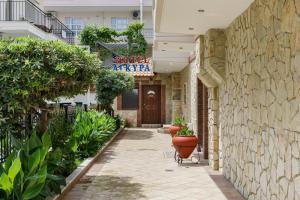 una pasarela con plantas y un cartel en un edificio en Agyra Seaview Hotel by Panel Hospitality, en Neoi Poroi