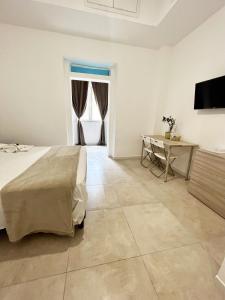 Un dormitorio con una cama, una mesa y un televisor. en B&B Numero5, en Castellammare di Stabia