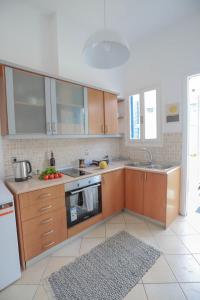 a kitchen with wooden cabinets and a sink at Rhodes Town Garden Apartment in Rhodes Town