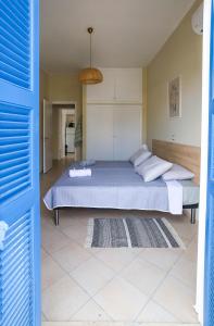 a bedroom with a bed and a blue door at Rhodes Town Garden Apartment in Rhodes Town