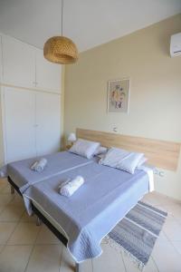 a bedroom with a blue bed with towels on it at Rhodes Town Garden Apartment in Rhodes Town