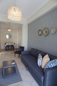 a living room with a blue couch and a table at Rhodes Town Garden Apartment in Rhodes Town