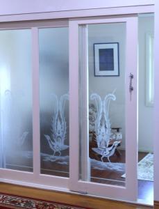 a glass door with a painting of birds on it at Gellibrand River Gallery Accommodation in Gellibrand