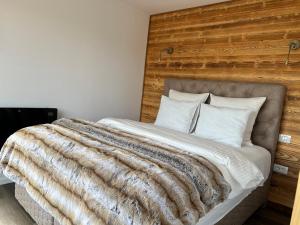 a bedroom with a large bed with a wooden headboard at Heaven`s cabins in Tău Bistra