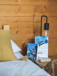 a bed with two books and a lamp on a table at Auberge Le Valezan in Valezan