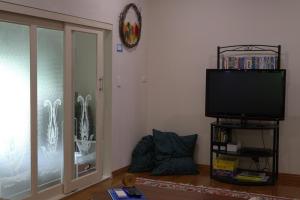 ein Wohnzimmer mit einem Flachbild-TV neben einem Fenster in der Unterkunft Gellibrand River Gallery Accommodation in Gellibrand