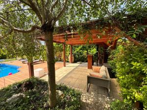 eine Terrasse mit einer hölzernen Pergola neben einem Pool in der Unterkunft Vácon Vár-lak Vendégház / Bird Nest Vác in Vác