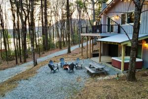 a house with chairs and a picnic table in the woods at Blue Ridge Hideaway at Lake Toxaway with Hot Tub in Lake Toxaway