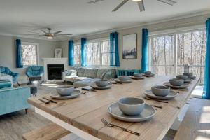 - une grande table en bois dans le salon avec des rideaux bleus dans l'établissement Blue Ridge Hideaway at Lake Toxaway with Hot Tub, à Lake Toxaway