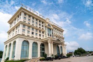 a large white building with a sign on top of it at ST Hotel Wattay Airport in Vientiane