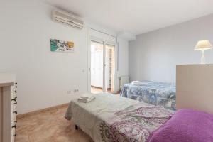 Una habitación blanca con dos camas y una ventana. en Malgrat, en Malgrat de Mar
