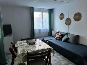 a living room with a table and a couch at Olívia Vendégház Orfű in Orfű