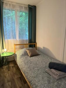 a bedroom with a bed and a window at Olívia Vendégház Orfű in Orfű