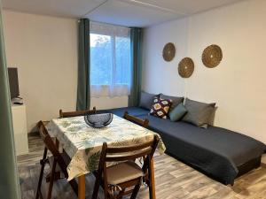 a living room with a bed and a table with chairs at Olívia Vendégház Orfű in Orfű
