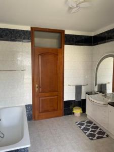 a bathroom with a wooden door and a sink at Villa Hoara in Gorizia