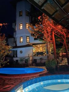 a view of the house from the pool at night at Keremidchieva Kushta Guest House in Sandanski