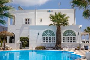 a villa with a swimming pool in front of a building at Blue Life Hotel in Emboríon