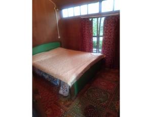 a small bed in a room with a window at House Boat Moti Mahal, Srinagar in Srinagar