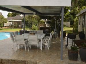 a patio with a table and chairs under a canopy at Rudys Guesthouse in Meyerton